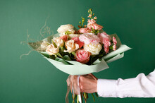 Man Holding And Giving A Beautiful Bouquet With Flowers To Woman On Green Background. Front View. Valentine's, Women's, Mother's Day, Love Concept.