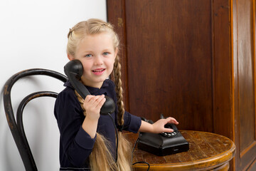 Wall Mural - Blonde girl talking by old black phone