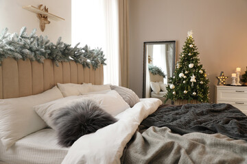 Poster - Beautiful decorated Christmas tree with fairy lights in bedroom interior