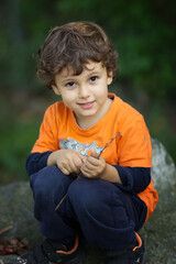 Close-up of portrait of a beautiful little boy 3-4 years old in a park in sunny day, childhood concept