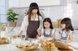 © Bangkok Click Studio - Beautiful Asian mother teaching two young daughters how to make a bakery in a modern kitchen. Idea for love and relationship of a family at home.