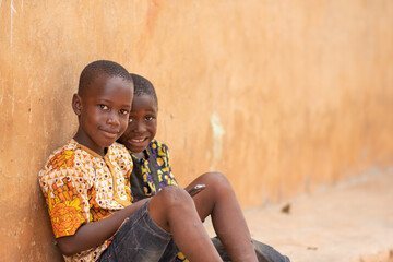 Wall Mural - two african kids smiling while using a phone