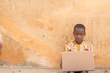 Wall Mural - african child using a laptop outside