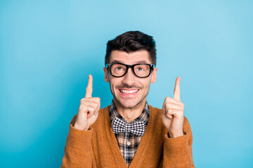 Sticker - Photo of positive person toothy smile look direct fingers up empty space isolated on blue color background