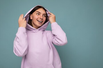 Shot of attractive happy smiling young woman wearing casual outfit standing isolated over colourful background with empty space looking to the side