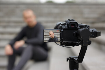 Wall Mural - handsome male blogger recording video with modern dslr camera