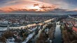 Panorama der Stadt Regensburg in Bayern mit dem Fluss Donau dem Dom und der steinernen Brücke im Winter mit Schnee und Eis während Sonnenuntergang, Deutschland