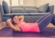 © SB Arts Media - Attractive woman on laptop in virtual online fitness class working out at home