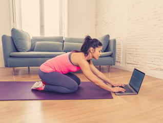 Wall Mural - Attractive woman on laptop in virtual online fitness class working out at home