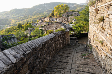 Wall Mural - Stone houses of traditional architecture and cobble-stone narrow street in Mikro Papigo in Epirus, Greece