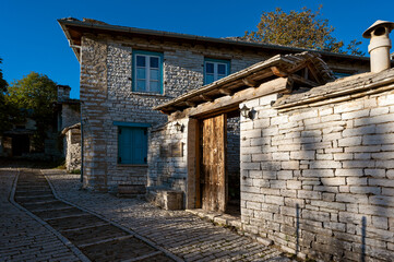 Wall Mural - Stone houses of traditional architecture and cobble-stone narrow street in Papigo in Epirus, Greece