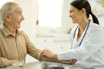 Wall Mural - Friendly doctor getting along well with her elderly patient