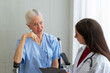 © ake - Caucasian old senior depressed upset woman patient on wheelchair talking to medical doctor with stethoscope  in hospital
