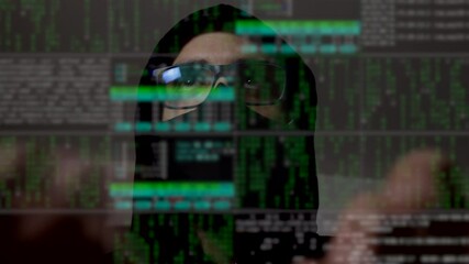 Time-lapse of a cyber hacker with binary code on the screen. Man face