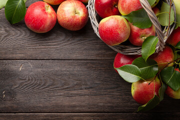 Poster - Ripe garden apple fruits in basket on wooden table