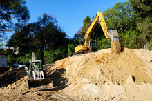 Excavator And Backhoe Working On A Hillside