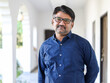 © Media Nation/Wirestock - Portrait of a middle-aged Indian male with eyeglasses wearing a blue shirt