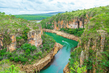 Tourist boat navigating between the Canyons of Furnas, Capitólio MG Brazil. Beautiful landscape of eco tourism of Minas Gerais state. Walls of sedimentary rocks and the green water of Lake of Furnas