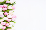 Fototapeta Tulipany - Pink and white tulips on a white background, selective focus. Mothers Day, birthday celebration concept.