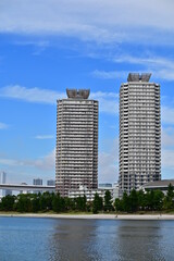 Two buildings with lake and people walking