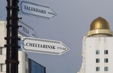 City Signpost With White Arrows Giving Directions To Salekhard, Tula And Chelyabinsk (Russia)