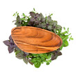 Empty wooden plate over various sweet basil herb leaves background. Healthy food concept. Top view with copy space.