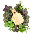 Empty wooden cutting board over various sweet basil herb leaves background. Healthy food concept. Top view with copy space.