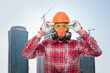 Builder puts on personal protective equipment on construction site. Job safety concept.