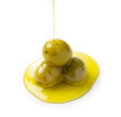 Pouring olive oil on olives placed on a white background