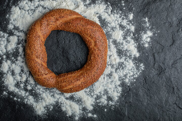 Wall Mural - Fresh and delicious Turkish simit on black background