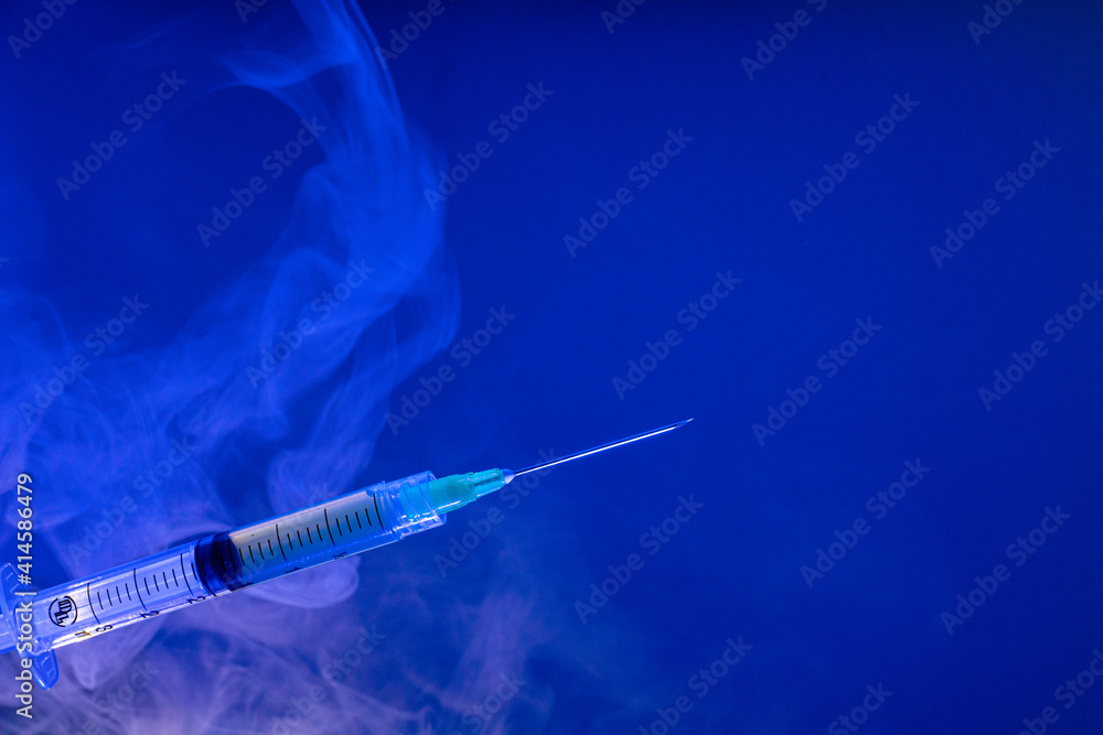 Jeringa hipodérmica para vacuna con fondo azul - obrazy, fototapety, plakaty 