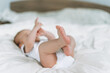 © Galina Zhigalova - Cute baby girl 2-4 month on bed with white linen, natural tones, selective focus