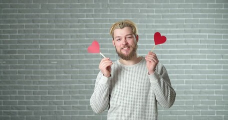 Wall Mural - Handsome man with red hearts on brick background