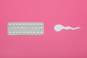 Birth control pills and spermatozoa made of paper on color background. Safe sex concept