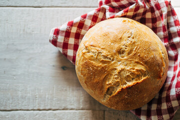 bread roll on red and white checkered towel on table