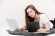 © Andriy Medvediuk - A seriously young girl in glasses sits with a laptop. Education, remote work and blogging. Isolated on a white background.