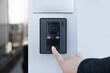 The female hand presses a button doorbell with camera and intercom