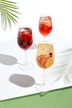 Assortment Of Sangria Drinks On White Table. Sunshine With Hard Shadow. Palm Leaves And Shadow. Fresh, Summer, Tropic, Beach Drink Concept
