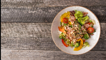 Wall Mural - Meat salad with fried bacon, pine nuts and vegetables. Rustic style. Top view, text space