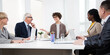 © chagin - Group of business people sitting around the office desk and discussing the project