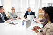 © chagin - Group of multi-ethnic business people sitting around the office desk and discussing the project