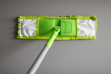 Wall Mural - Plastic mop with green microfiber cloth. Choosing a mop for home and office concept