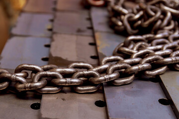 In the production hall there are iron chains for lifting large loads.