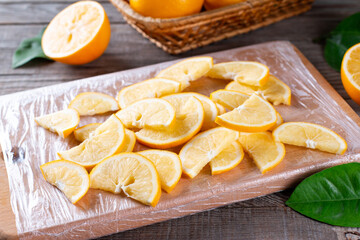 Wall Mural - Frozen lemon slices on a cutting board on a wooden table