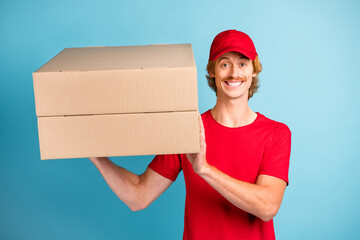 Sticker - Photo of cheerful person arms hold two boxes toothy smile headwear isolated on blue color background