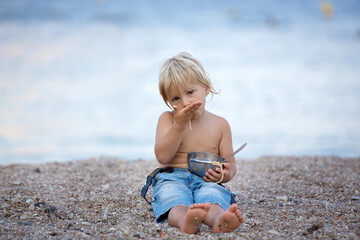 Sticker - Cute boy, child, eating spaghetti on the beach, enjoying dinner