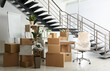 © New Africa - Cardboard boxes and furniture near stairs in office. Moving day