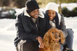 © prostooleh - People walks outside. Winter day. African couple with dog.