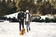 © prostooleh - People walks outside. Winter day. African couple with dog.
