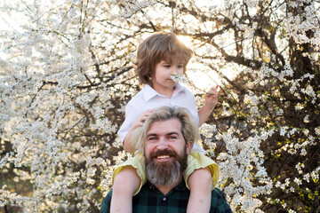 Wall Mural - Spring lovely family. Father and son. Dad child shoulder ride.